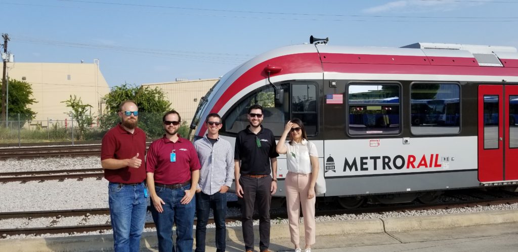 Transit Mobility team members in front of a Capital Metro Red Line train